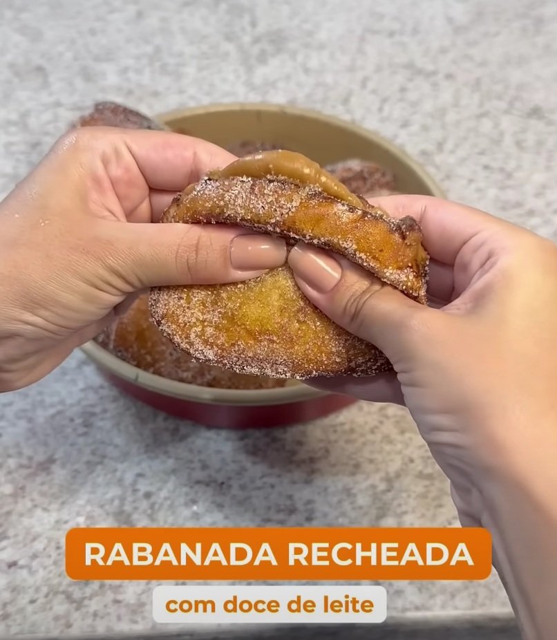 a person holding a doughnut in a bowl, rabanada recheada com doce de leite