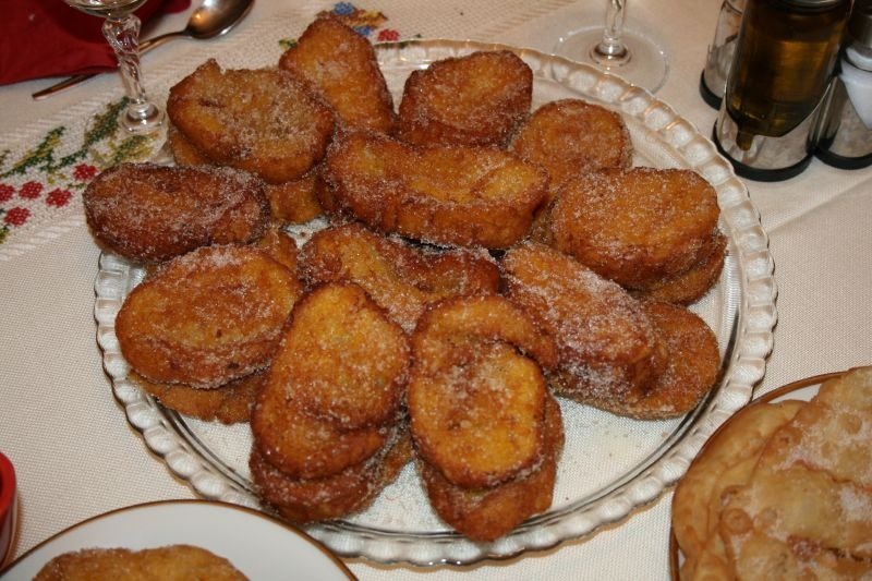 a plate of rabanada and a glass, food table